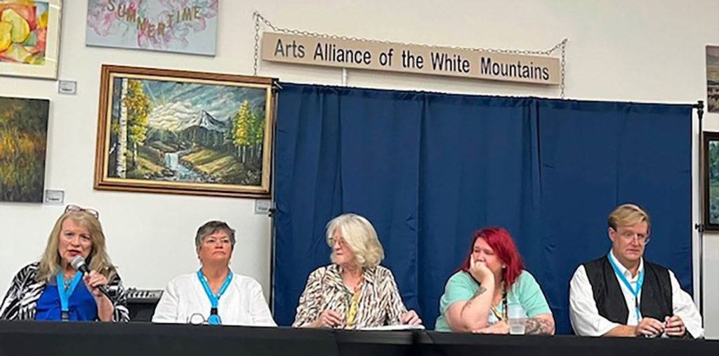 Panel discussion featuring five speakers at the Arts Alliance of the White Mountains, surrounded by artwork.
